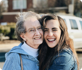 Grandma with her daughter smiling and hugging each other dearly