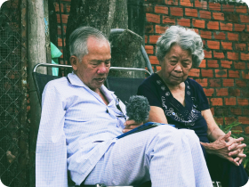 an Asian elderly couple sitting outside together